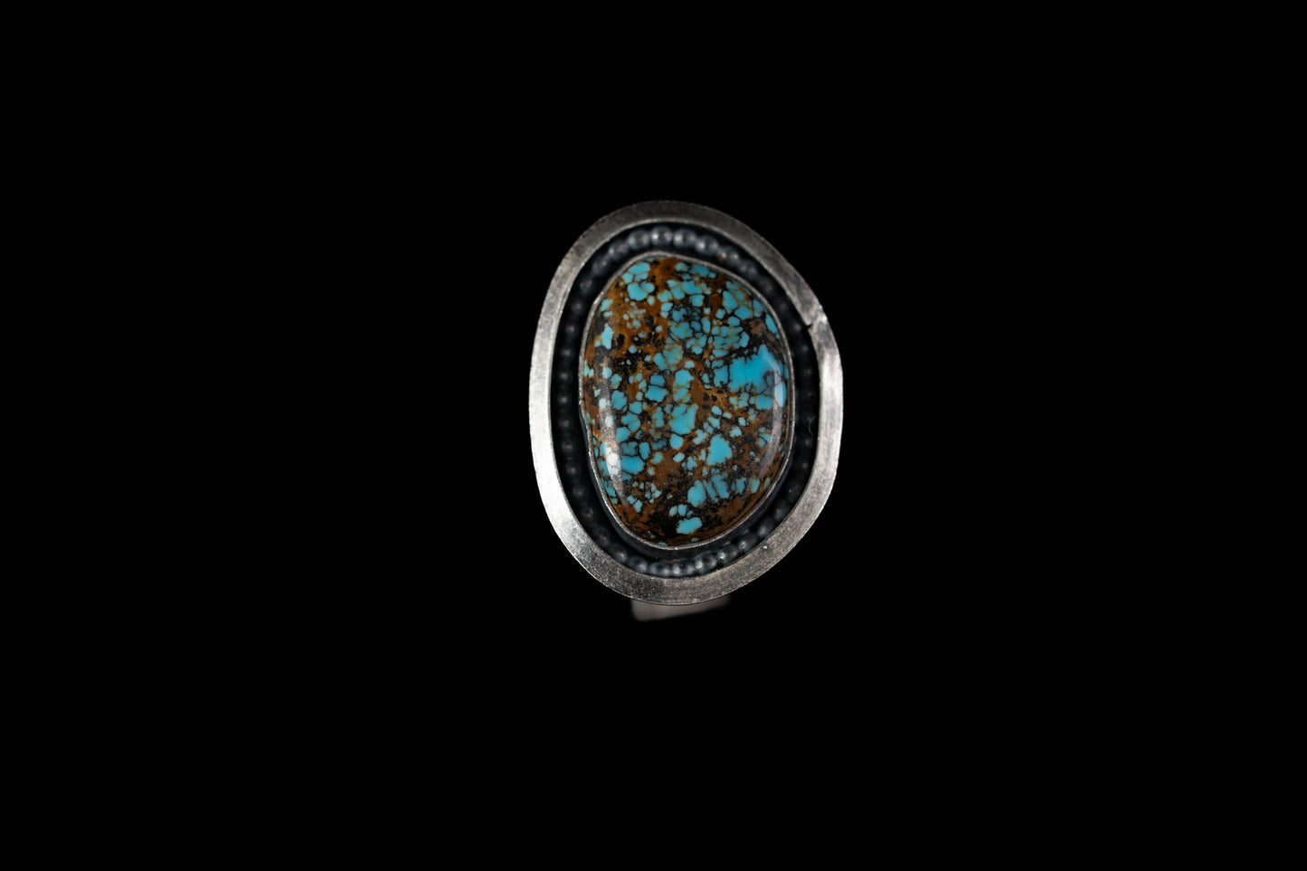 Ring with a turquoise stone on a black background