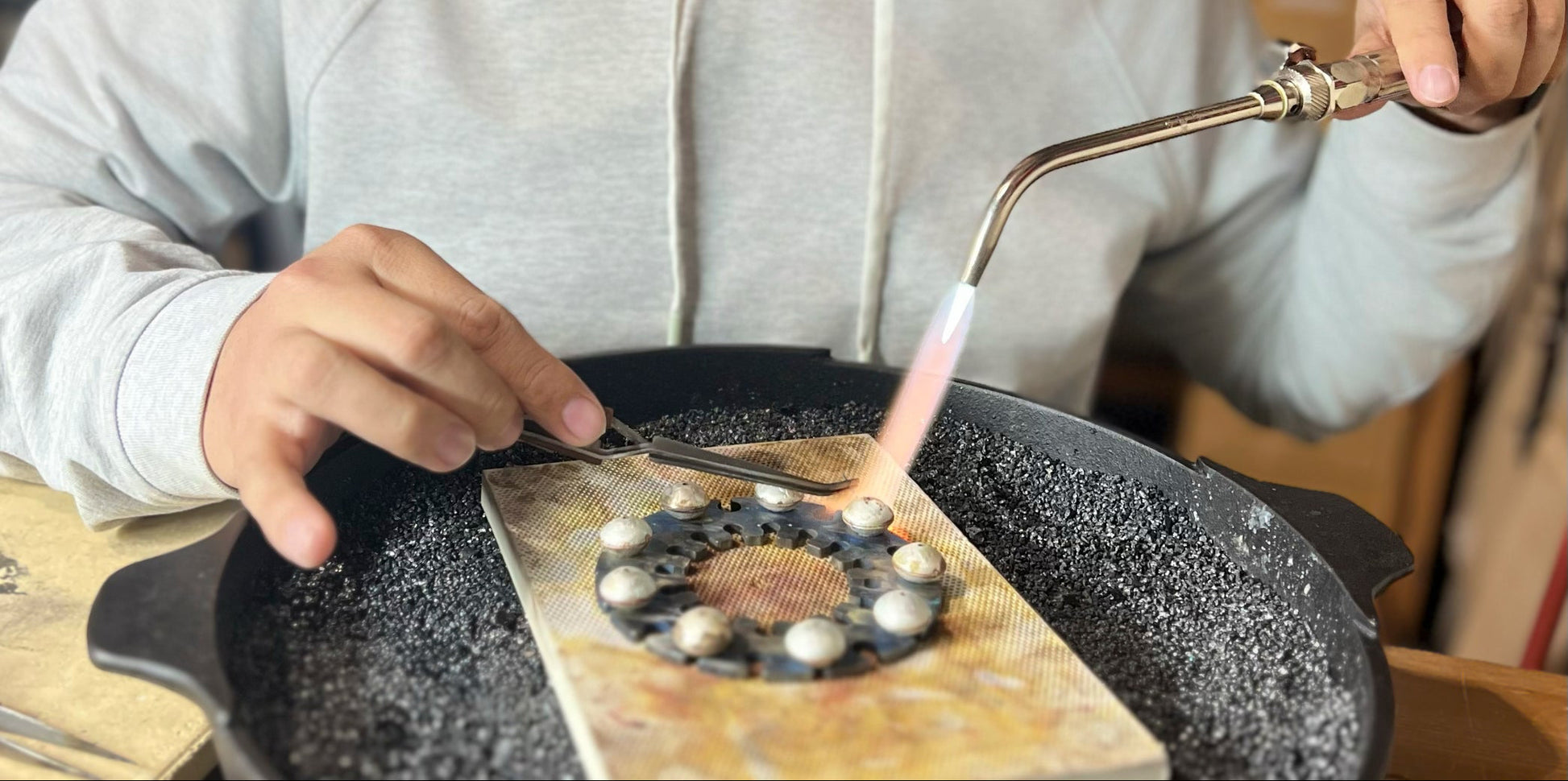 Person using titanium Bead Soldering Disc
to solder dime beads together